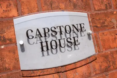 a sign on a brick wall with the wordsoperative house at Bifolds, enclosed garden. Southport character home in Southport