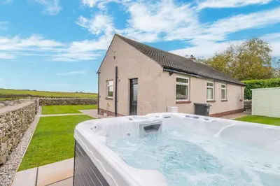 a hot tub in the backyard of a house at Colt Park Cottage in Ulverston