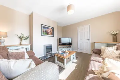 a living room with a couch and a tv at Colt Park Cottage in Ulverston