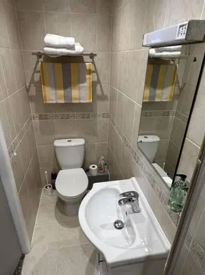 a small bathroom with a toilet and a sink at O’er The Yard Hideaway in Blackpool