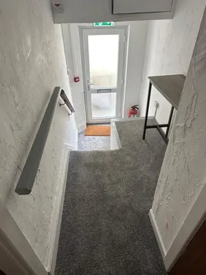 a room with a staircase with a door and a table at O’er The Yard Hideaway in Blackpool