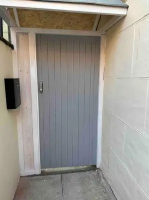 a garage with a purple door on the side of a building at O’er The Yard Hideaway in Blackpool