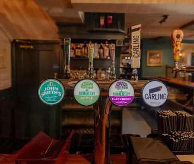 a group of signs on a pole in a bar at Ye Olde Original Withy Trees in Bamber Bridge