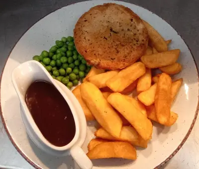 a plate of food with peas and a sandwich and sauce at Ye Olde Original Withy Trees in Bamber Bridge