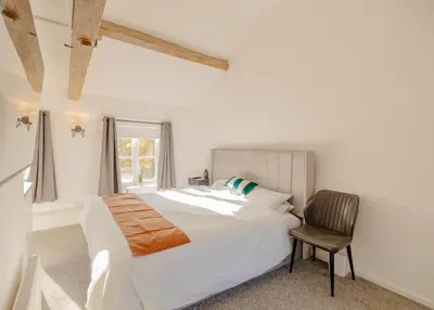 a white bedroom with a bed and a chair at Ye Olde Original Withy Trees in Bamber Bridge