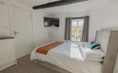 a bedroom with a large bed and a window at Ye Olde Original Withy Trees in Bamber Bridge