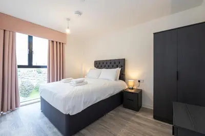 a bedroom with a large bed and a large window at GuestReady - Delightful getaway in Liverpool in Liverpool