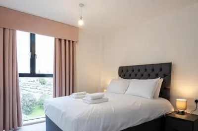 a bedroom with a bed with white sheets and a window at GuestReady - Delightful getaway in Liverpool in Liverpool