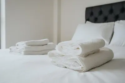 a pile of towels sitting on top of a bed at GuestReady - Delightful getaway in Liverpool in Liverpool