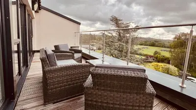 a balcony with wicker chairs and tables on a building at River View in Preston