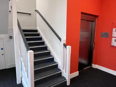 a staircase in a building with a red wall at River View in Preston