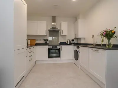 a kitchen with white cabinets and a vase of flowers at River View in Preston