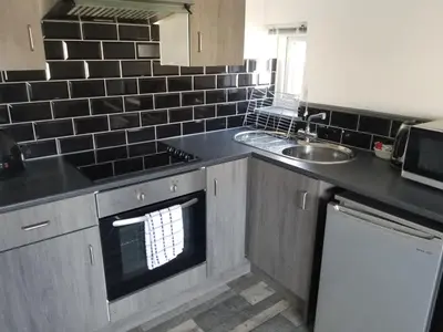 a kitchen with a sink and a stove top oven at The Sandalwood Hotel in Blackpool