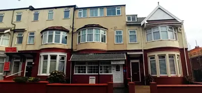 a large building with blue shutters on it at The Sandalwood Hotel in Blackpool
