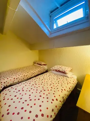 a bed in a small room with a window at Delamere Hotel in Blackpool