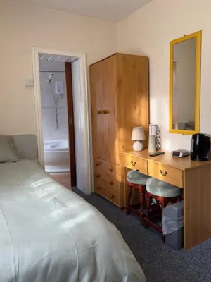 a bedroom with a desk with a bed and a mirror at Delamere Hotel in Blackpool