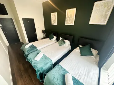 two beds in a room with green and white at The Valley Inn Liverpool in Liverpool
