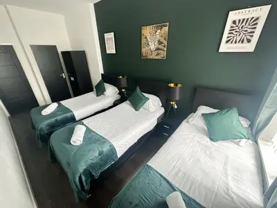 two beds in a room with green walls at The Valley Inn Liverpool in Liverpool