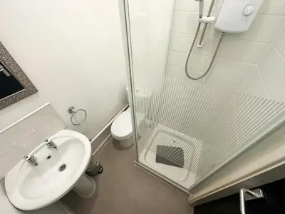 a bathroom with a shower and a sink and a toilet at The Valley Inn Liverpool in Liverpool