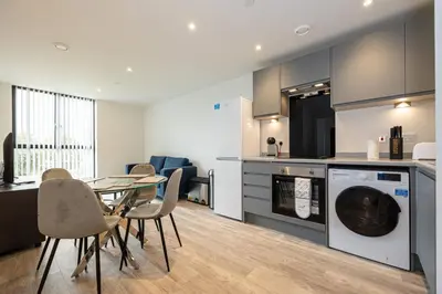 a kitchen and dining room with a table and a dishwasher at GuestReady - Lux getaway in Liverpool in Liverpool