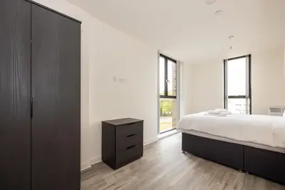 a bedroom with a large bed and a dresser at GuestReady - Lux getaway in Liverpool in Liverpool