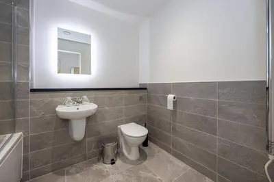a bathroom with a toilet and a sink and a mirror at GuestReady - Lux getaway in Liverpool in Liverpool