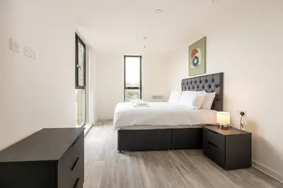 a white bedroom with a large bed and a desk at GuestReady - Lux getaway in Liverpool in Liverpool