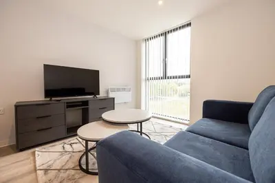 a living room with a blue couch and a tv at GuestReady - Lux getaway in Liverpool in Liverpool