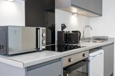a kitchen counter with a microwave and a sink at GuestReady - Stunning studio in Liverpool in Liverpool