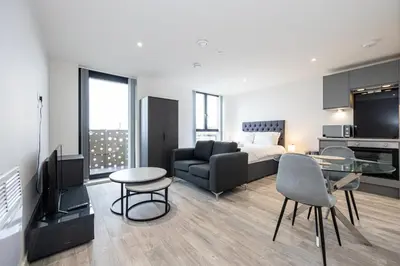 a living room with a bed and a couch and a television at GuestReady - Stunning studio in Liverpool in Liverpool