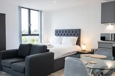 a bedroom with a bed and a couch and a table at GuestReady - Stunning studio in Liverpool in Liverpool