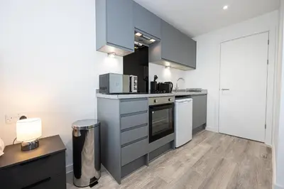 a kitchen with blue cabinets and a stove top oven at GuestReady - Stunning studio in Liverpool in Liverpool
