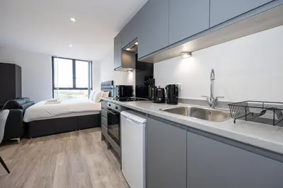a kitchen with a sink and a bed in a room at GuestReady - Stunning studio in Liverpool in Liverpool