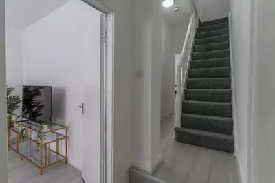 a staircase in a white room with a stair case at Modern 4bedroom Spacious Family Home in Liverpool