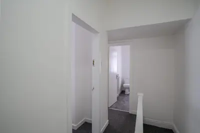 a white room with a toilet and a hallway at Modern 4bedroom Spacious Family Home in Liverpool