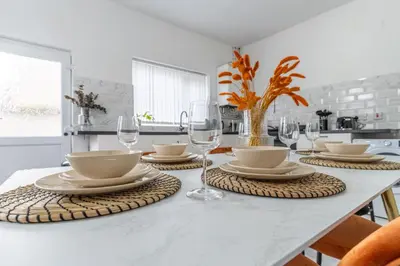 a dining room table with plates and glasses on it at Modern 4bedroom Spacious Family Home in Liverpool
