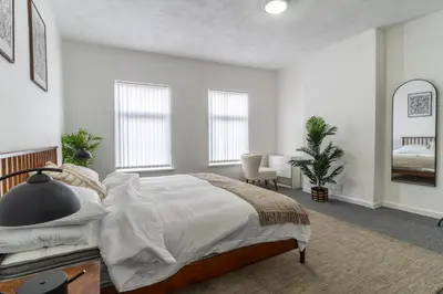 a white bedroom with a large bed and a desk at Modern 4bedroom Spacious Family Home in Liverpool