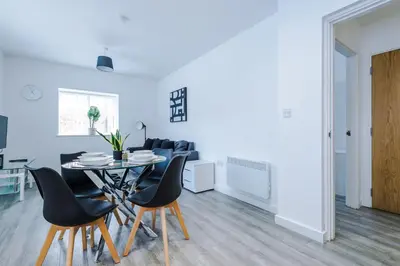 a dining room and living room with a table and chairs at Victoria Mill by Staycay in Wigan