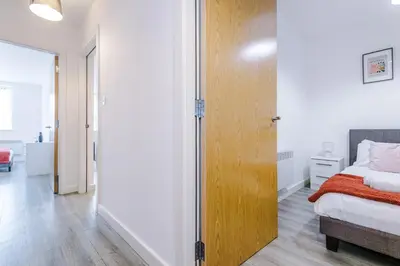 a bedroom with a bed and a wooden door at Victoria Mill by Staycay in Wigan