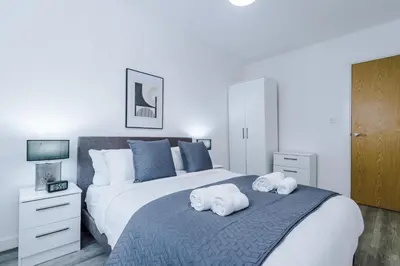 a bedroom with a large bed with towels on it at Victoria Mill by Staycay in Wigan