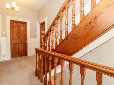 a staircase in a home with wooden railings at Church View in Grange Over Sands