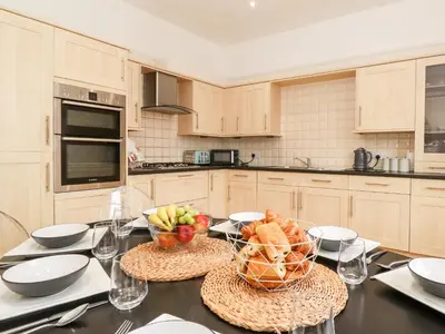 a kitchen with a table with a basket of fruit on it at Church View in Grange Over Sands