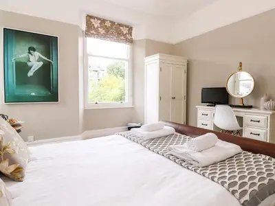 a bedroom with a large white bed with a window at Church View in Grange Over Sands