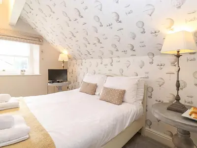 a bedroom with a white bed and a wall covered in butterflies at Church View in Grange Over Sands