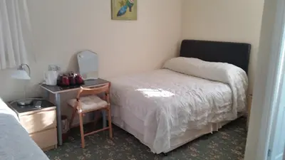 a bedroom with a bed and a desk with a chair at Beachcomber Hotel in Blackpool