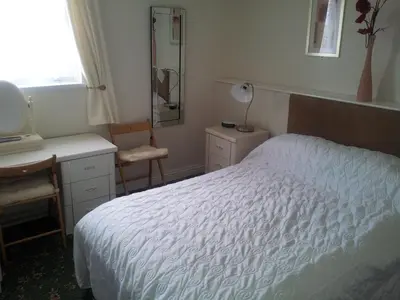 a bedroom with a bed and a desk and a mirror at Beachcomber Hotel in Blackpool