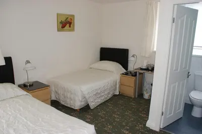 a hotel room with two beds and a toilet at Beachcomber Hotel in Blackpool