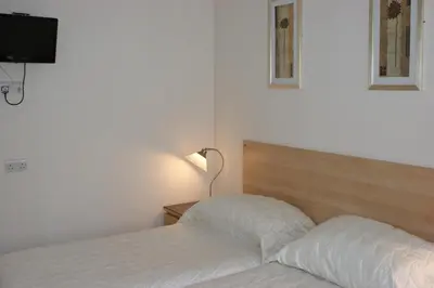 a bedroom with a bed and a lamp and a television at Beachcomber Hotel in Blackpool
