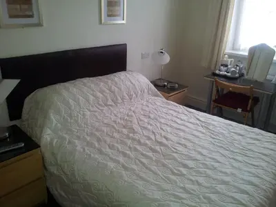 a bedroom with a bed and a desk and a window at Beachcomber Hotel in Blackpool