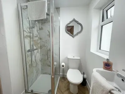 a bathroom with a shower and a toilet and a sink at Beach House By Sasco in Blackpool